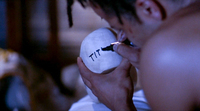 Basquiat writes black text on a white ball.