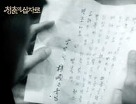 Close-up image of hands holding a handwritten letter of calligraphy.