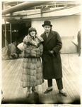 Black-and-white photograph of two actors on the deck of a ship arriving in New York harbor.