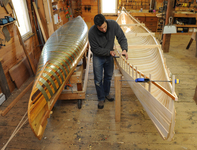 Dylan Schoelzel makes wood-and-canvas canoes at Salmon Falls Canoe in Massachusetts. Note the metal bands on the canoe form at left.