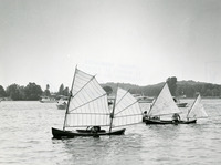 A Rushton batwing sailing canoe in front with a lateen-rigged sailing canoe behind it.