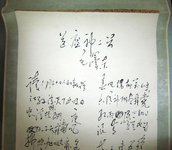 A calligraphy scroll with white background, trimmed with green and yellow, with black horizontal calligraphic text at top and then in two columns.