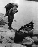 Arthur Carhart, at the Superior National Forest in 1920, demonstrates how to stack and carry two canoe packs.