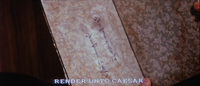 Black calligraphy is written on a diary in closeup and on beautiful, decorative paper. An Engliish subtitle at the bottom translates in all caps: "RENDER UNTO CAESAR."