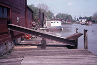 A color photograph of the exterior of Kishman Fish Co. building ramp over dock towards water.