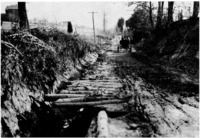 Dirt road repaired with pine poles in the pre-automobile era