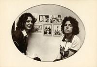 Oval photograph of the two press founders seated, shown from the waist up, both with long, wavy hair. Behind them, six Helaine Victoria Enterprises postcards are mounted on the wall.