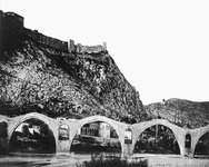 Bridge in Buna River with Shkodër Castle on a cliff  in the background.