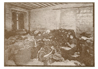 Three women sit on the floor in a dismal, dark room surrounded by heaps of rags, some piled on the floor and others in baskets. They seem to blend in among the rags piled around them.