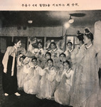 Figure 11.2. Choe in simple everyday Korean dress in her studio instructing a group of dancers in Korean costume, some with fans and others in long sleeves and scarves.