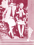 Photo shows the two sitting on a stone wall dressed in skirts and jackets. Hall wears a tie. Hall’s arm is slipped under her partner’s arm, touching Troubridge’s hand.