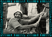 Photo from album cover “Mabley Breaks It Up.” With a big smile and her signature hat, she swings a sledgehammer. Background shows demolition view with a crumbling building.