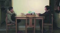 A shot from Small Talk showing a mother talking to her daughter across a dining table.