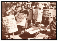 Women and children in warm coats march on New York City streets carrying signs that read, “integration means better schools for all” and “Jim crow can't teach democracy.”