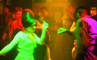 A shot from Buddha Bless America showing a local hostess dancing with a Black American GI in a crowded nightclub.