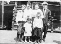 Black and white photograph of family standing in front of a tenement.