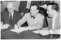 Signing the Ford-UAW contract. Left to right: Philip Murray, President of the CIO; Harry Bennett; and R. J. Thomas, President of the UAW