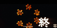 Bold, white letter reading "The End" is superimposed on a circle of flowers on a black matte background.