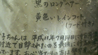 Close-up image of a piece of paper with water droplets and black calligraphy on it.