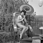 Black and white photograph, 1964 New York World’s Fair, Miss Republic of China visits Hong Kong Pavilion in rickshaw, umbrella in hand