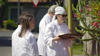 Color screenshot from a documentary film showing four adults with Intellectual and Developmental Disability facing to the right, dressed in white chef uniforms. One person holds a brown tray.