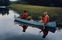 A color photograph of Homer Dodge and Margaret Wing Dodge paddling an aluminum canoe.