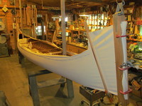 Canvas being stretched over a 1905 Morris Veazie model canoe. Note the tacks at the gunwale that hold the canvas to the boat.