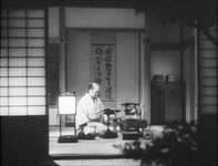 A scroll decorates the tokonoma in the background of the room of Chamberlain Oishi.