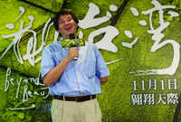 A press conference photo showing the deceased director Po-­lin Chi speaking in front of an image from his documentary Beyond Beauty: Taiwan from Above.