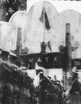 This blurred black-­and-­white photo shows the blue-­sky-­white-­sun flag flying on top of a memorial archway (paifang) that bears the calligraphy of Sun Yat-­sen: tianxia weigong (All-­under-­Heaven serves public good). A triangle pennant bearing the words “heping fangong jianguo” (peace, anticommunism, nation-­building) is attached to the bottom of the flagpole. Three rows of soldiers are standing at attention below the archway, apparently waiting for inspection.