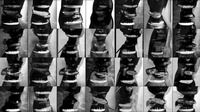 Video still: Grid of black and white photo squares with seven squares across and four squares down. Each square has an abstracted human mouth.