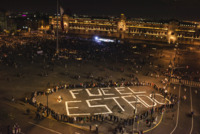 Bird’s-eye view of the Zócalo with protesters at night. Some protesters surround the phrase “Fue el Estado,” painted in enormous letters on the square’s floor.