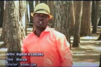 A man in a beige fedora looks at the camera in what appears to be a music video still. Credits for the video are listed on the screen, including the artist’s name, Bigman Gadzama, as well as the title of the song and the name of the director of the video.