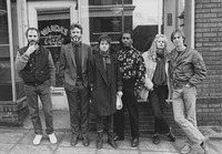 Six people lined up together in front of a building