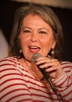 Photo of Roseanne Barr holding a microphone.