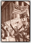 Large crowd marching. Women carrying banners saying “BEWARE CAPITALIST BOYS! HERE COMES A LEAGUE OF AMAZONS AGAINST NUKES” and “WOMYN AGAINST NUKES.”