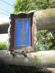 Photograph of worn wooden sign, with calligraphy faded.