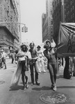 Outdoor image of several people walking in the street during a march. Cropped banner for Street Transvestite Action Revolutionaries.