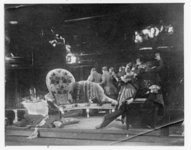 In this photograph, the officer-in-transit (Kelberer) sprawls on the stage (left) and Khlestakov (Garin) lies collapsed in a chair (right), both in a drunken stupor, while the Major’s wife (Raikh) guides the town officials out on tiptoe.