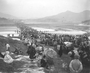 A black-­and-­white photograph of Korean War refugees moving southward in the early stages of the Korean War