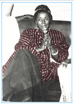 Springer-Kemp speaks at the African American Labor Center in Timbuktu. Holding a microphone, she wears a dashiki and long skirt, her hair pulled back in a high bun.