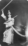 Figure 2.2. In a crown of jewels and finely embroidered garment, Mei Lanfang strikes a dance pose wielding two swords, one held high and the other low. Long sashes float behind him.