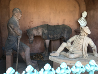 Sculptural grouping at Laurel Hill Cemetery of Sir Walter Scott standing on the left, his character Old Mortality sitting on a box tomb on the right, and Old Mortality’s horse behind the two men.