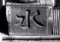 A calligraphy character is engraved into a stone block.