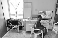 Photograph of a teenager watching TV in the new apartment.