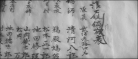 Closeup of a list of names, written from right to left and bound with a tied cord.