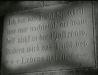 Image of a script carved on the wall of Cologne Cathedral. The original German script is followed by an edited image of English script