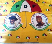 Textile depicting photographs of  “H.E. Chief James Onanenefe Ibori” and of “H. E. Senator Ifeanyi Athur Okowa” beneath a large umbrella reading “PDP.”