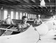 A black-and-white photograph of employees at the Old Town Canoe Company constructing canoes.