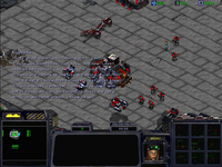 An in-game screenshot. Sarah Kerrigan's sprite is on the field in teal, her face on the bottom screen and (optionally) her dialogs are subtitled. Terran normal units and buildings are indicated in red.